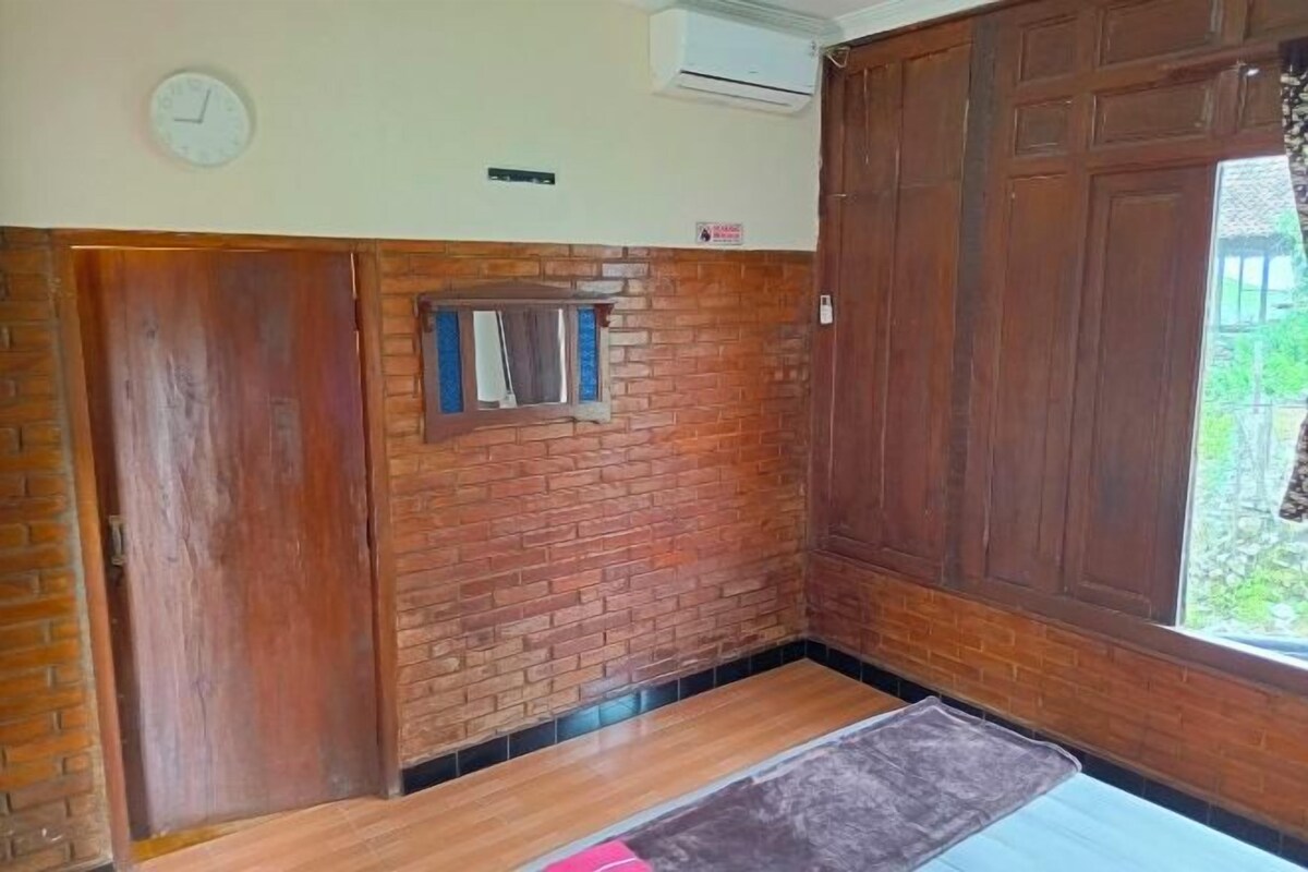 A room with a brick wall, wooden door, and a window.