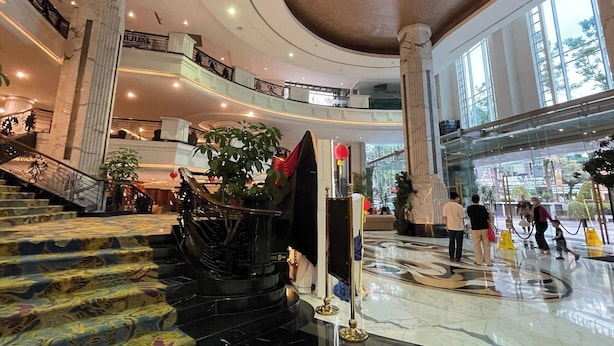 A multi-level atrium with marble floors, a grand staircase, and large columns.