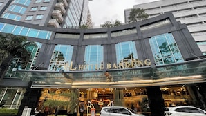 A hotel with a modern glass facade, multiple balconies, and a prominent entrance.