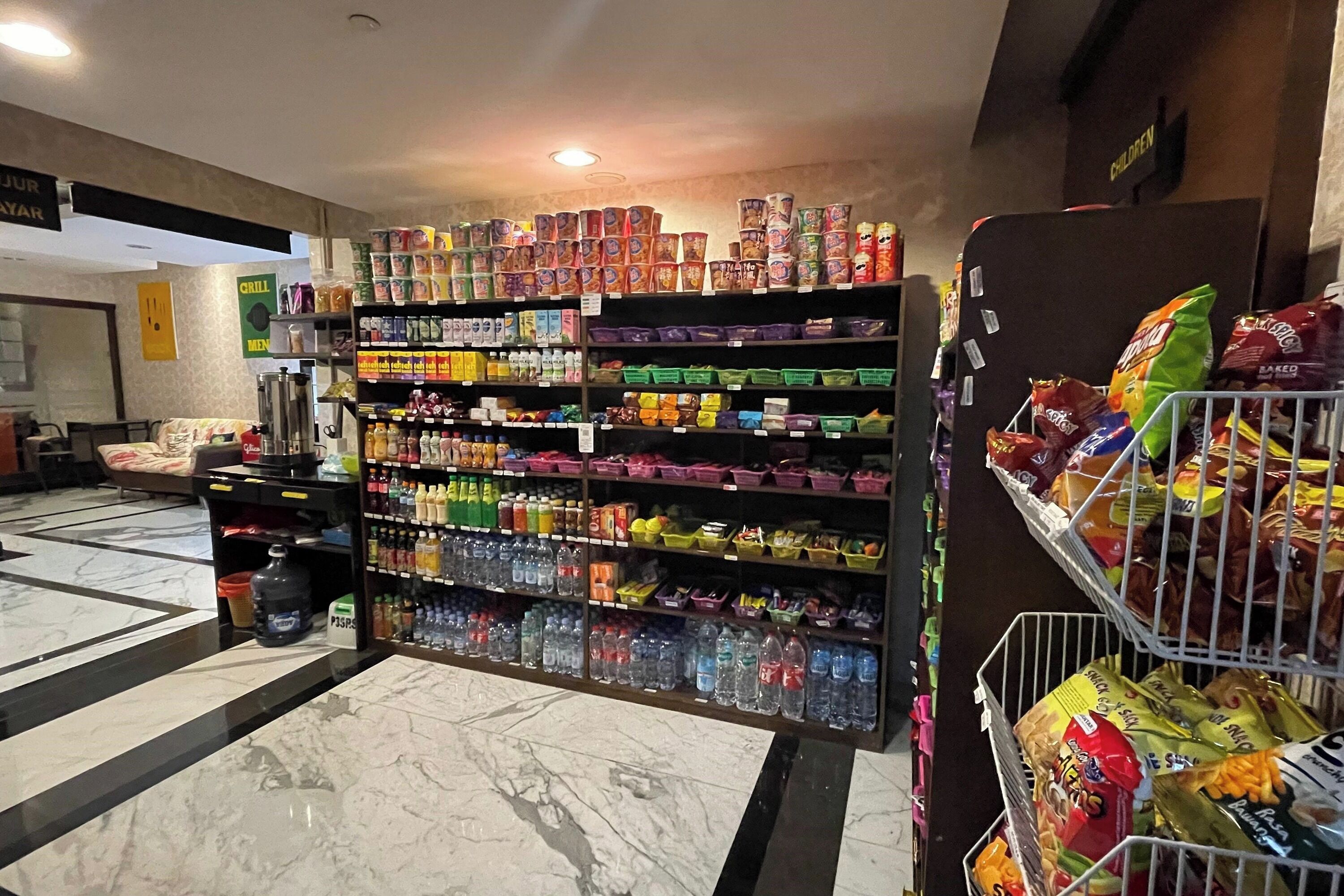A grocery store with shelves stocked with various products, a water dispenser, and a section for snacks.
