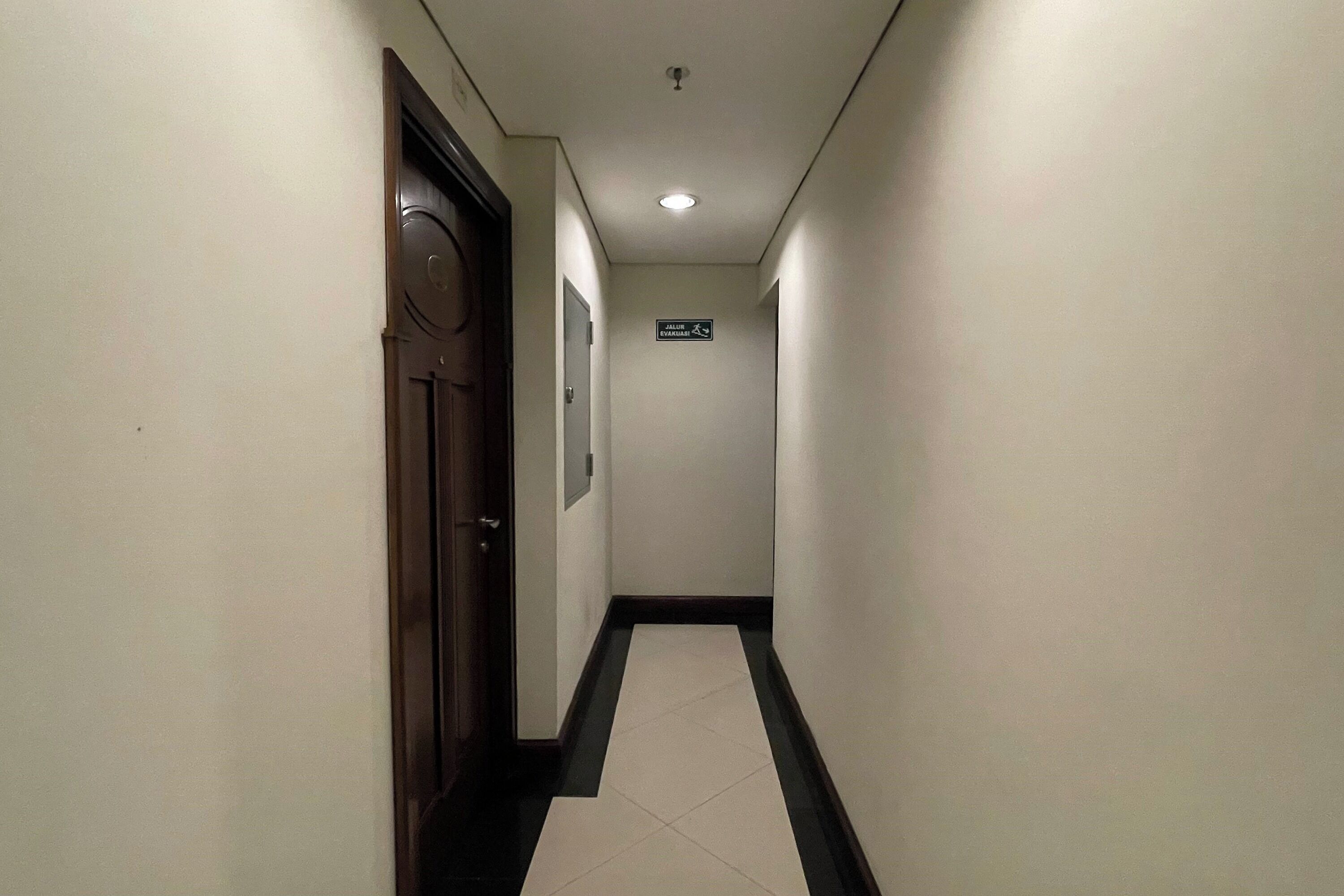 Un couloir étroit avec un panneau indiquant l’emplacement des toilettes.