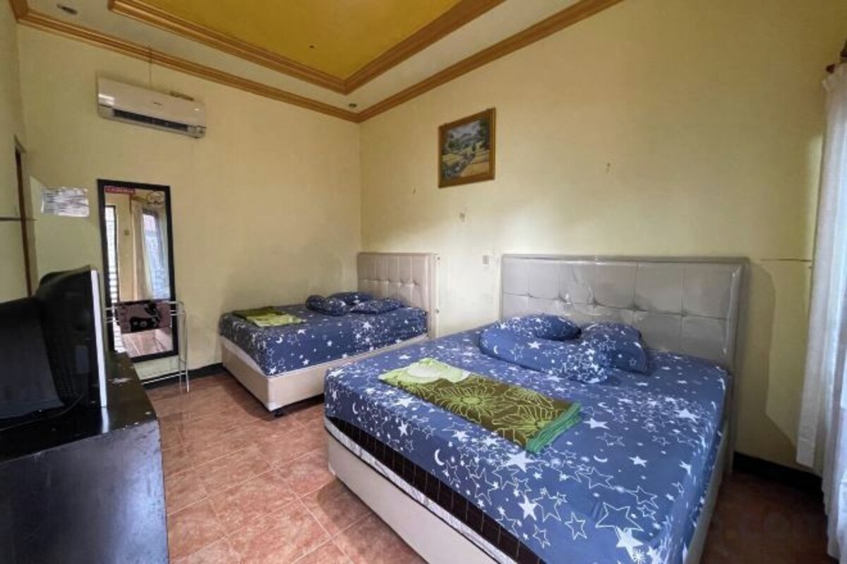 Une chambre avec deux lits, un bureau et une chaise.