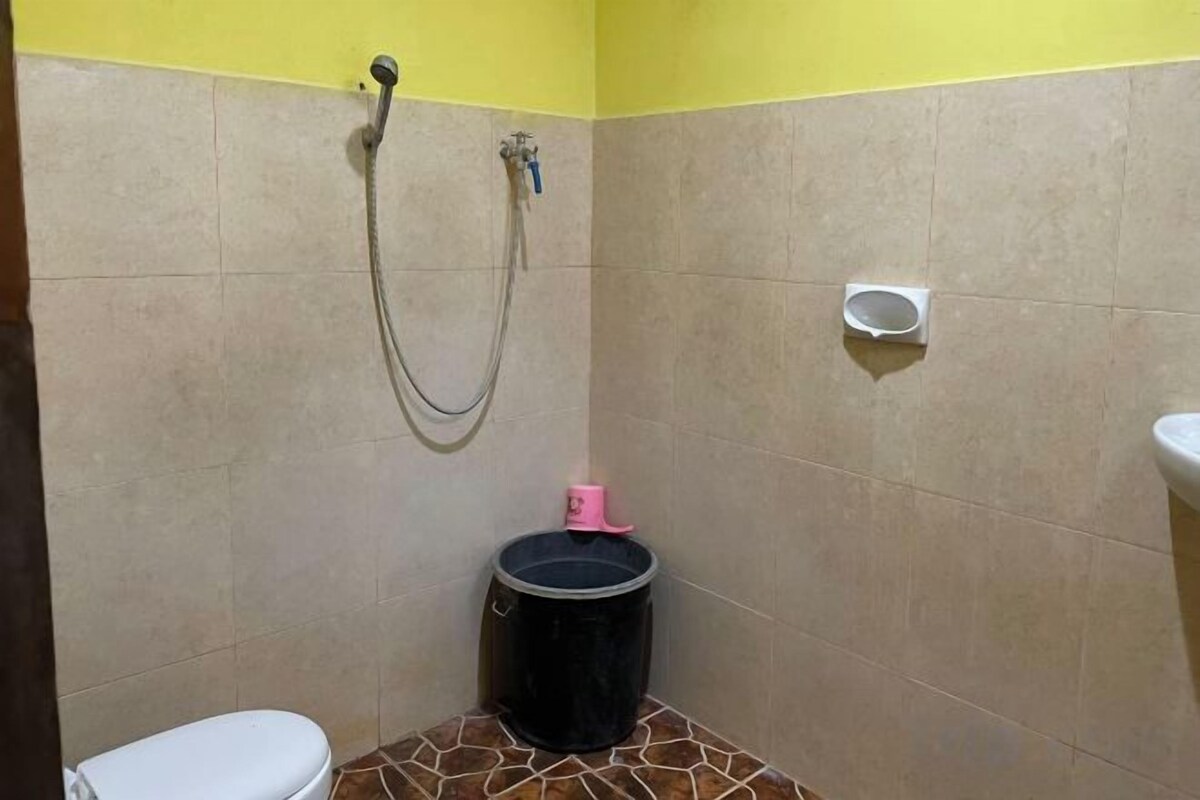 Ein kleines Badezimmer mit Toilette, Dusche und Mülleimer.