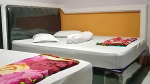 Een hotelkamer met een bed, een raam met gordijnen en een wand met een structuur.