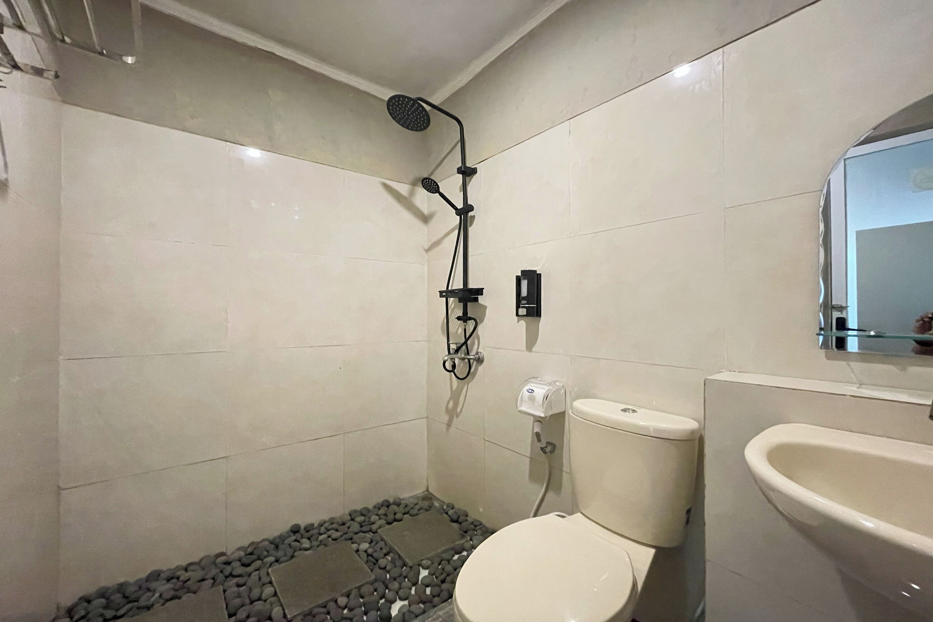 A bathroom with a toilet, a sink, and a shower with a handheld showerhead.
