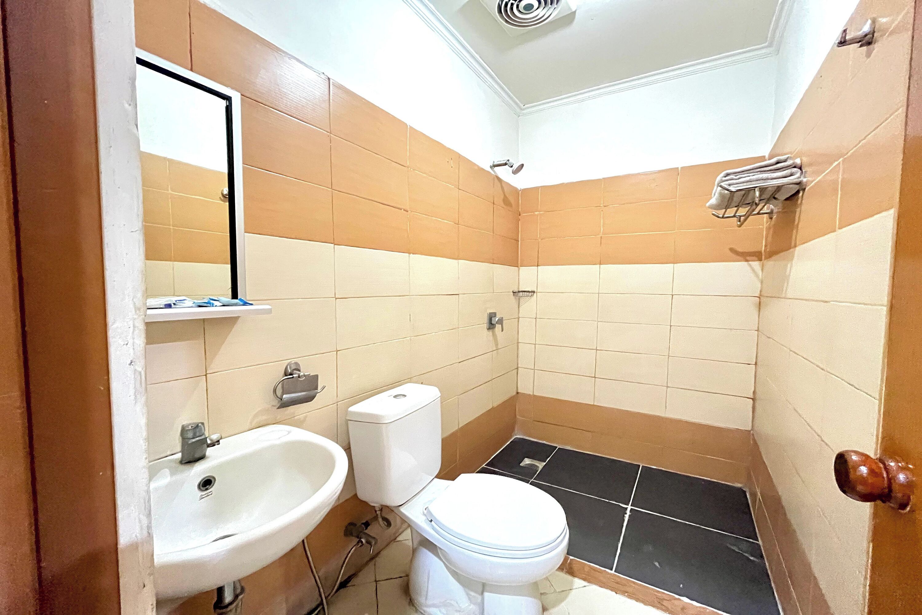 Un bagno con il water, un lavandino e un portasciugamani.