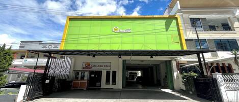 Un edificio con fachada verde y un letrero que dice 'MAISON'.