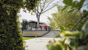 A paved pathway leading to a building with a red canopy. - Daoneua Riverside Resort (Muang Fuang)