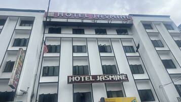 A multi-story building with the sign "HOTEL JASMINE" prominently displayed.