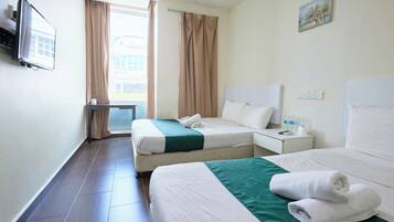 Habitación de hotel con dos camas, televisor, ventana con cortinas y un cuadro en la pared.