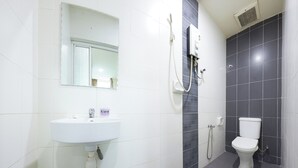 Un baño con lavamanos blanco, un espejo, ducha y retrete.