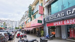 Vista de la calle con un hotel y una tienda llamada 'XPERT GADO'.