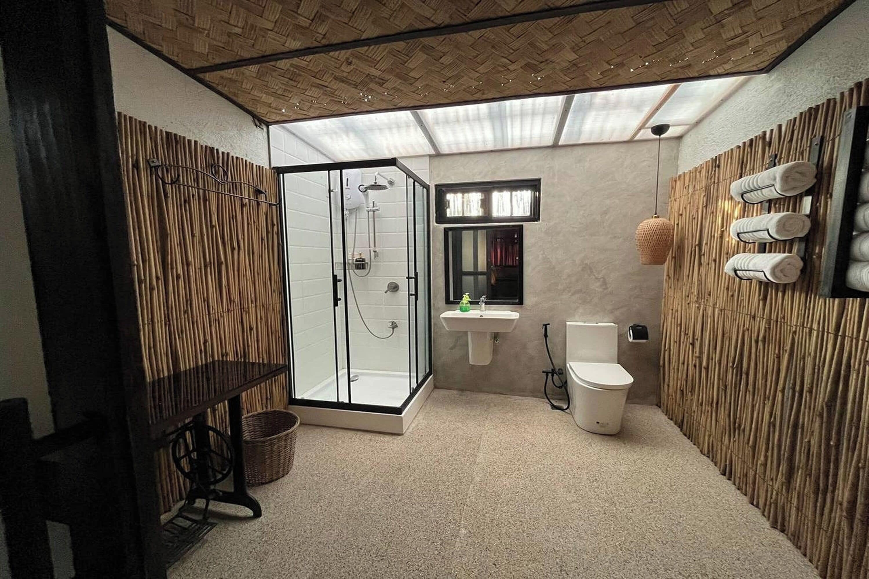A bathroom with a glass-enclosed shower, a sink, and a toilet.