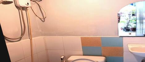 Un baño con inodoro, ducha y lavamanos.