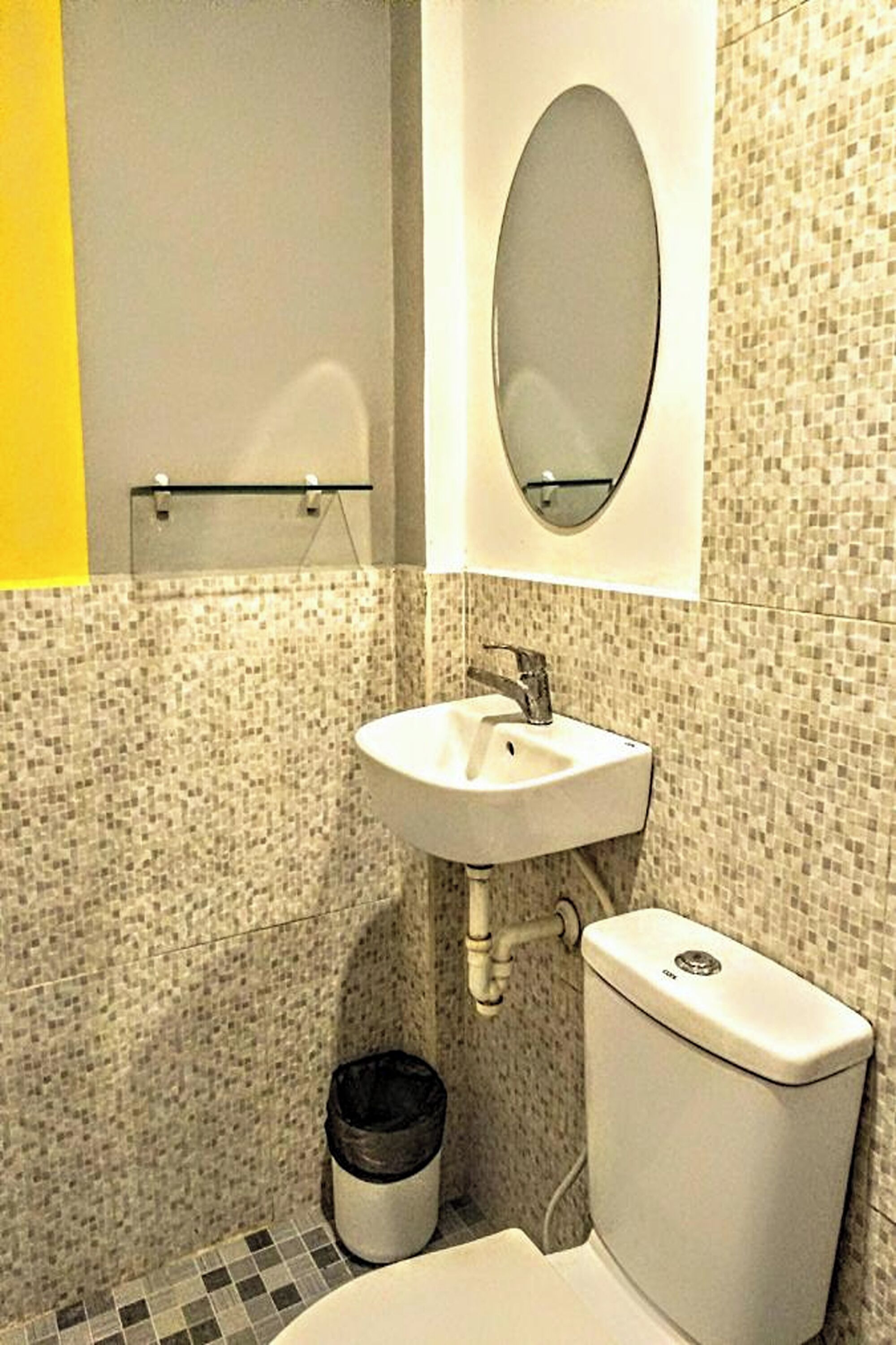 A bathroom with a white sink, a mirror, and a toilet.