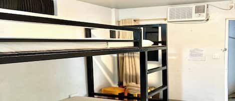 Habitación con literas, ventilador de techo y aire acondicionado.