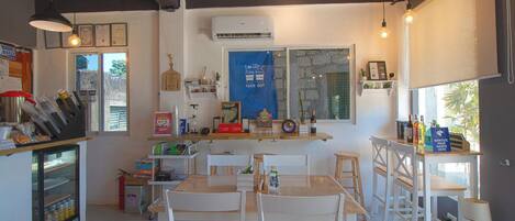 A café with a counter, seating area, and a window with a 'Take Out' sign.