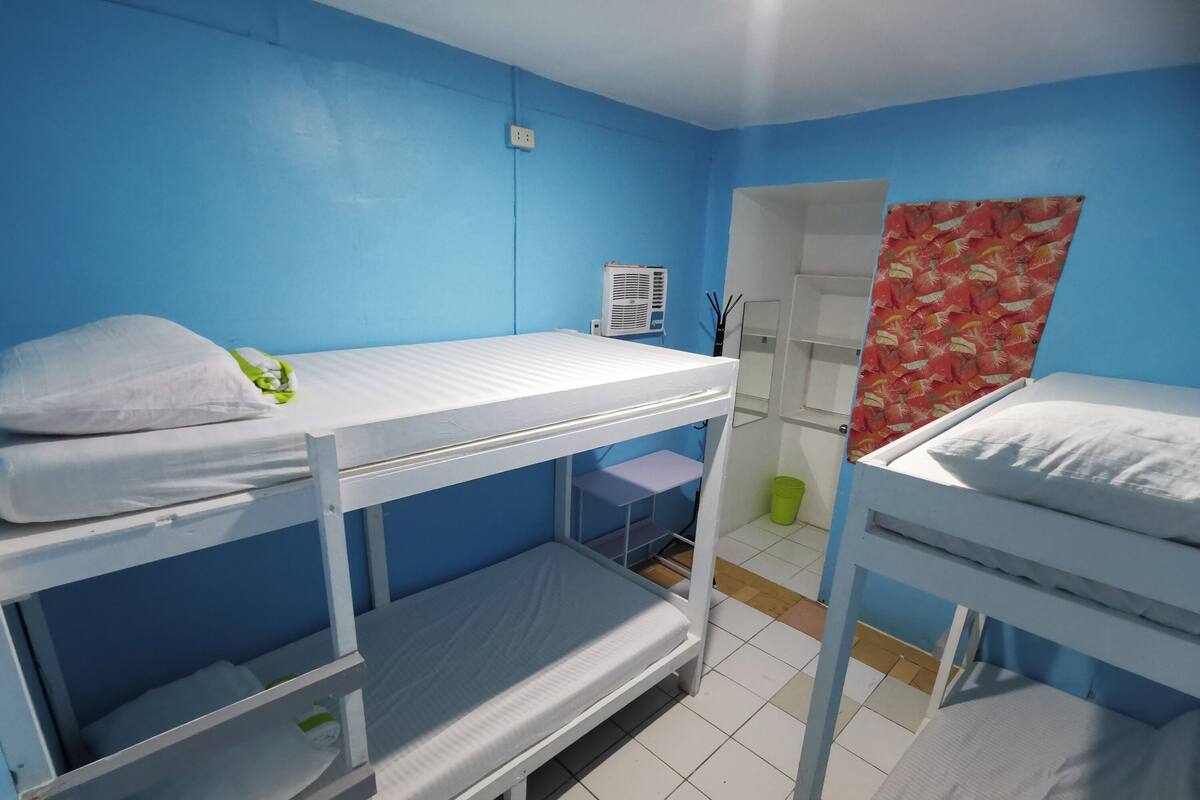 Un dormitorio con literas, una mesita pequeña y un espejo.