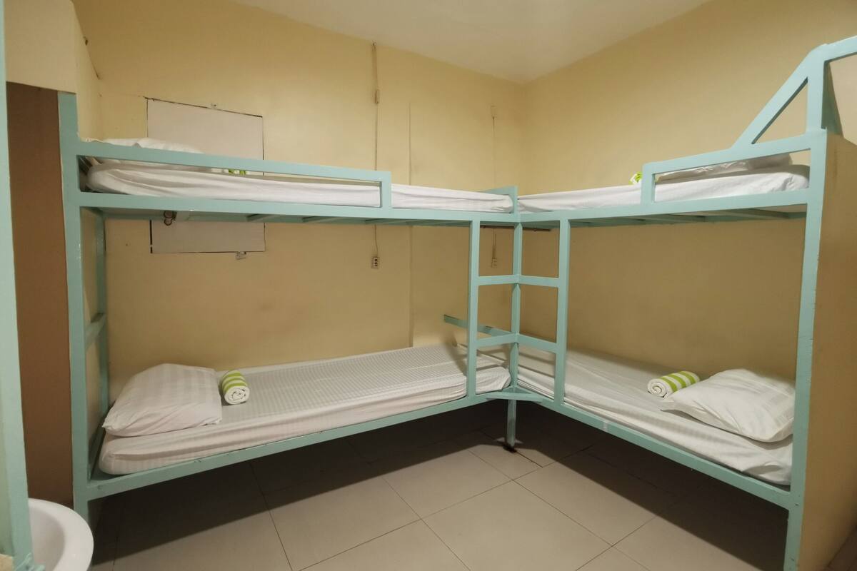 Habitación con literas, un inodoro y un estante pequeño.