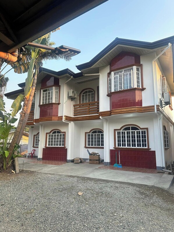 A two-story house with a red and white exterior, multiple windows, and a balcony. - Keps Boarding House (San Fernando)