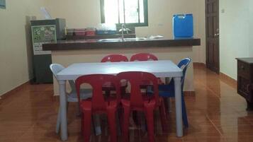 Une petite cuisine équipée d’une table et de chaises, d’une fenêtre et d’un distributeur d’eau.
