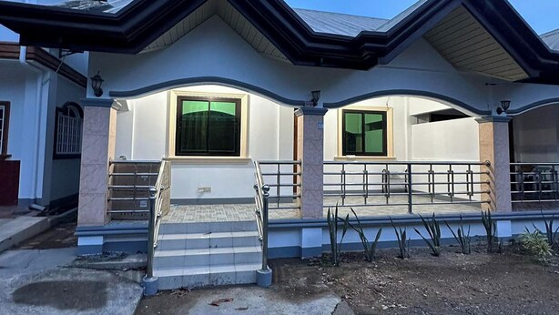 A two-story house with a front porch, a staircase, and a garage. - Keps Boarding House (San Fernando)