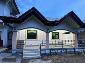 A two-story house with a front porch, a staircase, and a garage. - Keps Boarding House (San Fernando)