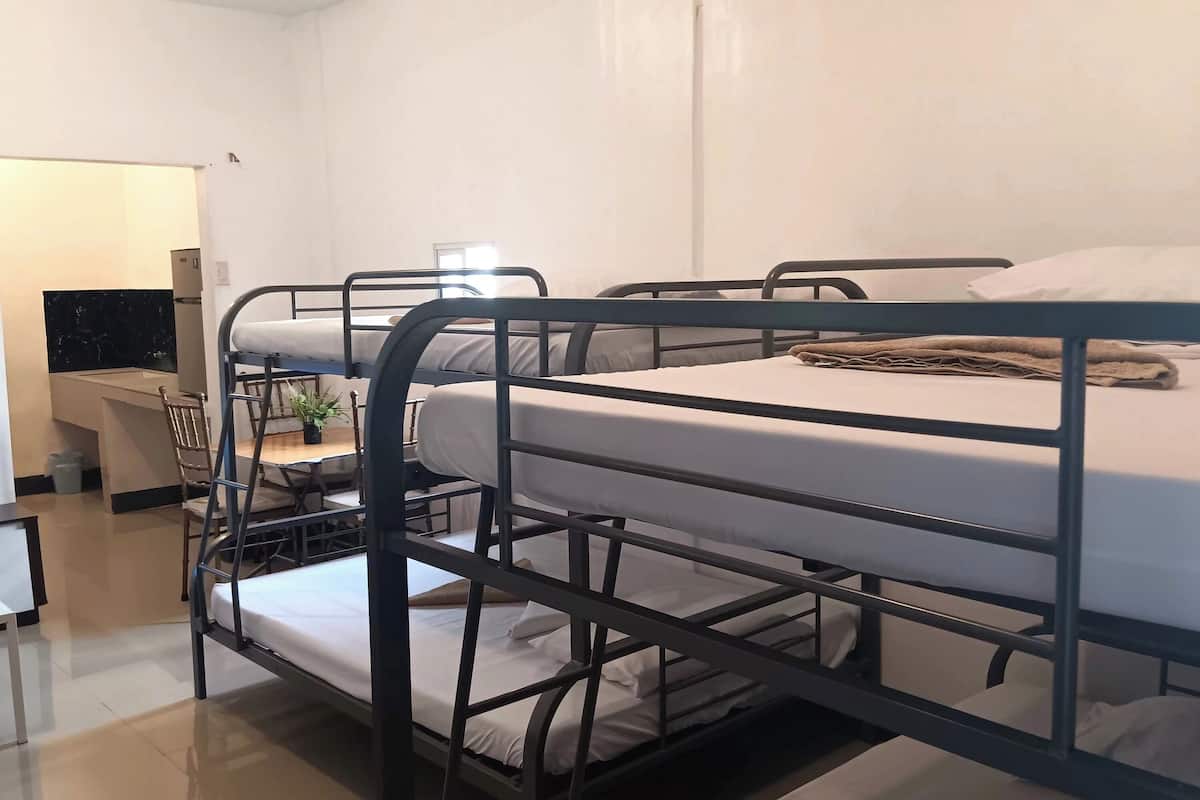 Un dormitorio con literas, un escritorio y una silla.