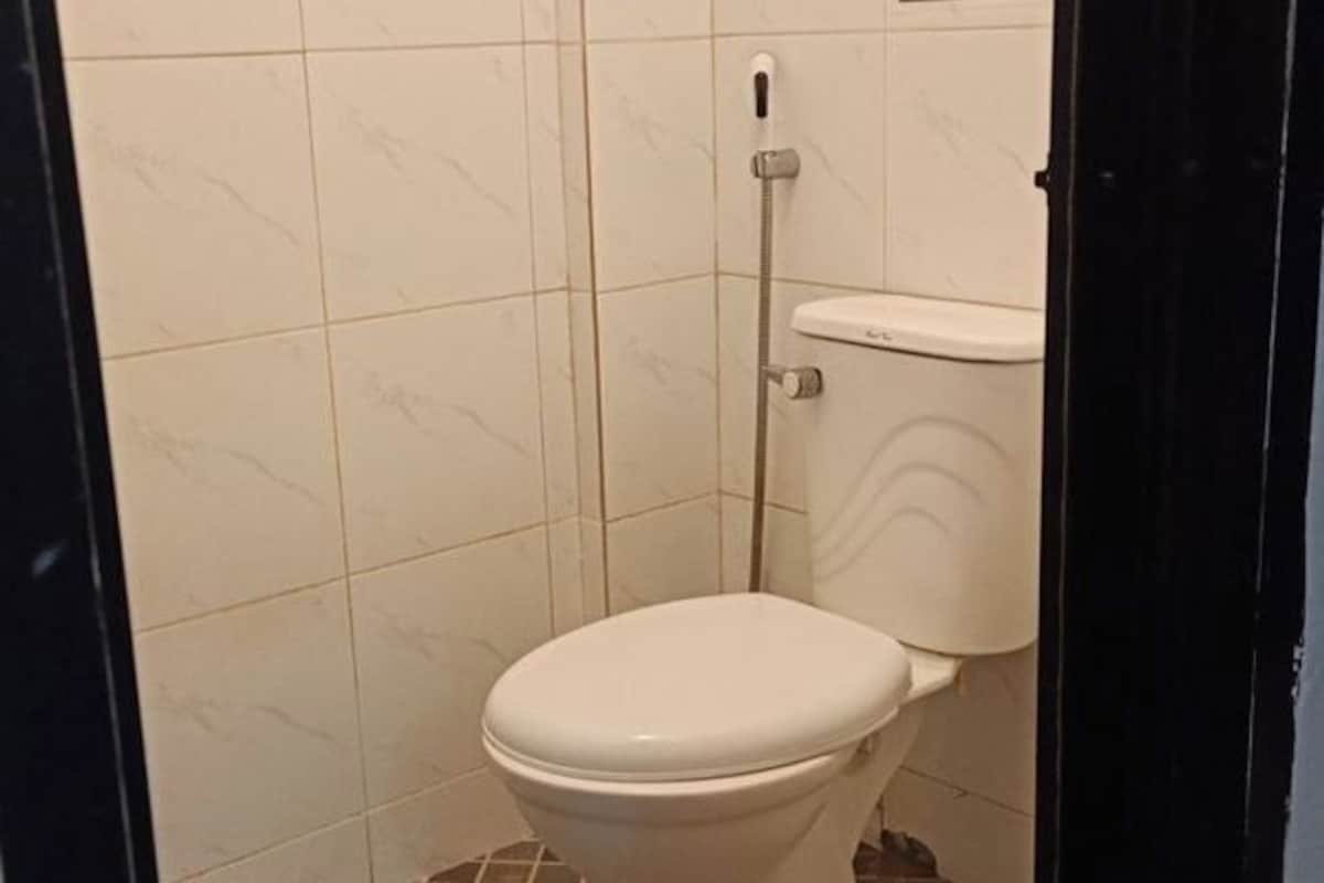 Une petite salle de bain compacte, équipée de toilettes et d’une cabine de douche.