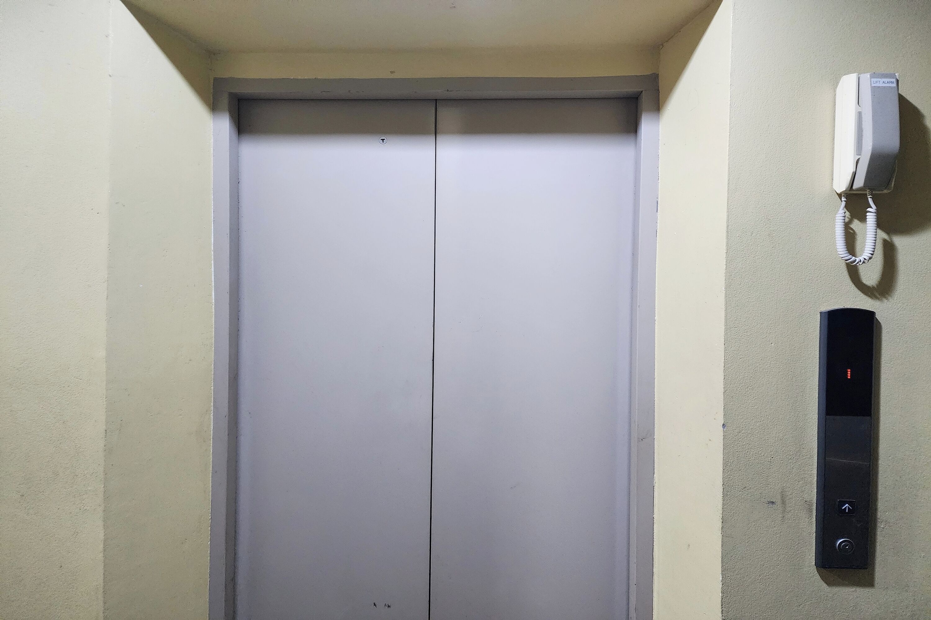 Un ascensor con un teléfono en la pared y un panel de control.