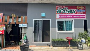 A building with a signboard, a window, and a small outdoor seating area.