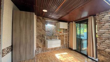 Enjoy a serene bathroom retreat with a sink, bathtub, and garden view.