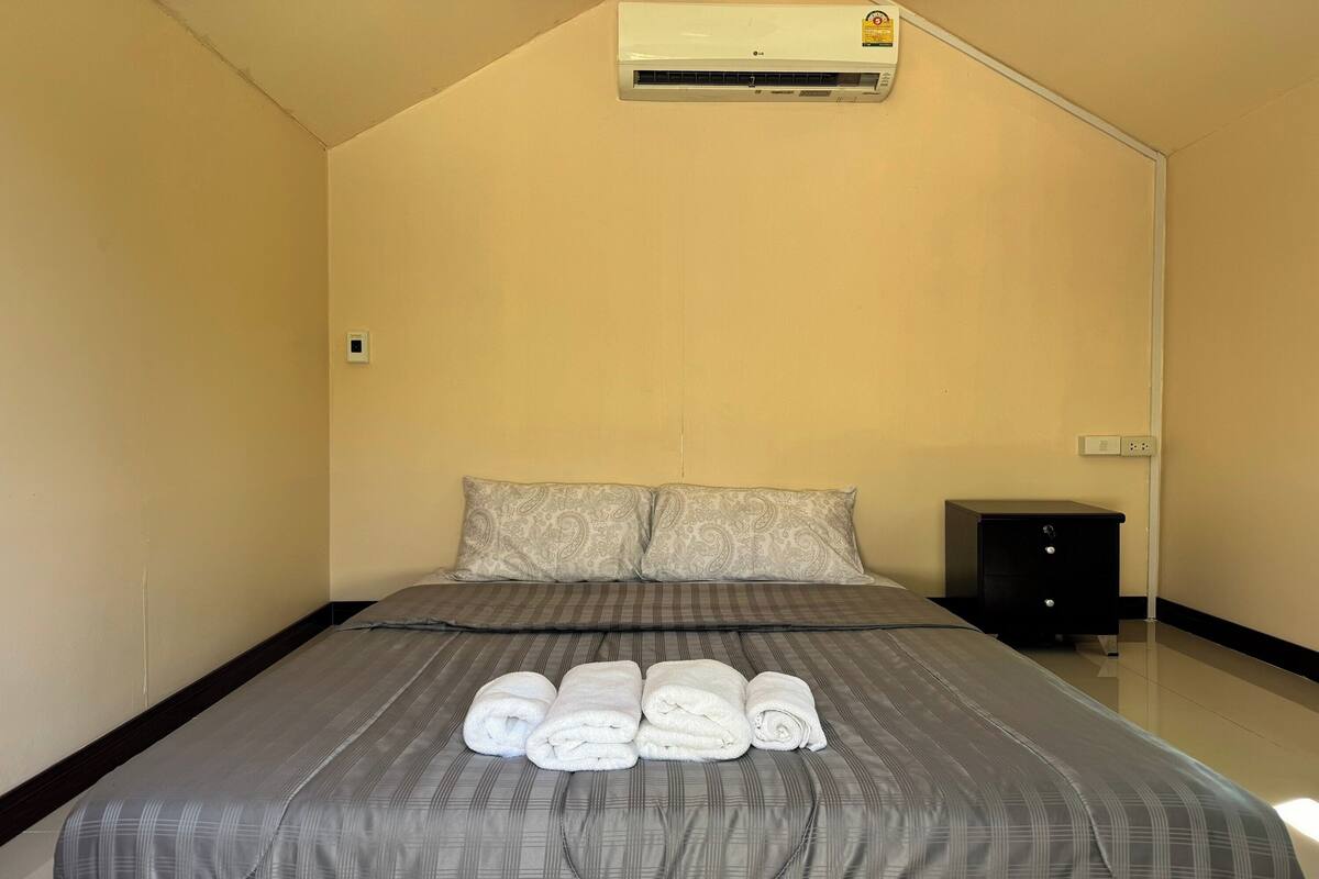 Une chambre d’hôtel équipée d’un lit, d’une table de chevet et d’un appareil de climatisation.