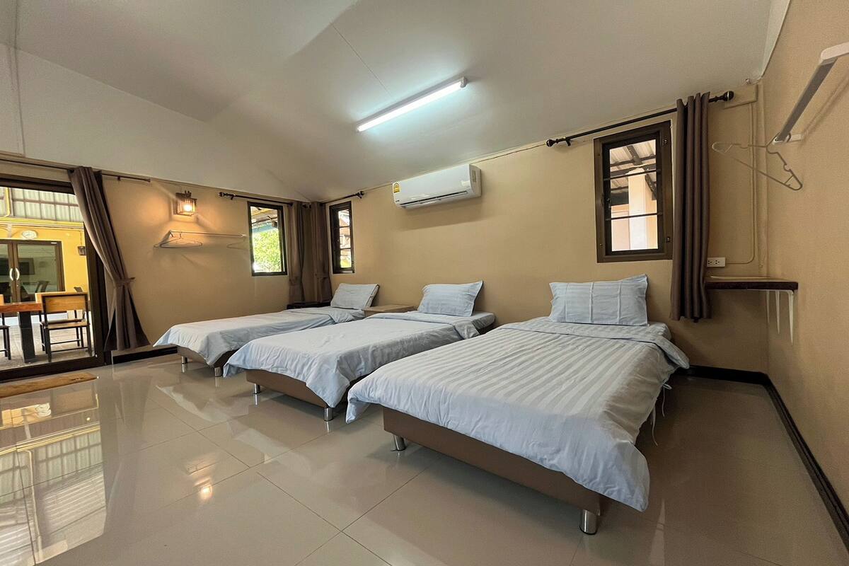 Une chambre d’hôtel avec deux lits, un coin repas et un appareil de climatisation.