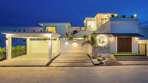 A modern two-story house with a well-lit entrance, a visible garage, and a landscaped front yard. - The Modern Pool Villa Hua Hin (Hua Hin)