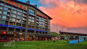 A hotel with multiple floors, a ski in and ski out facility, and a large field with tents. - YunDing Grand Hotel (Zhangjiakou)