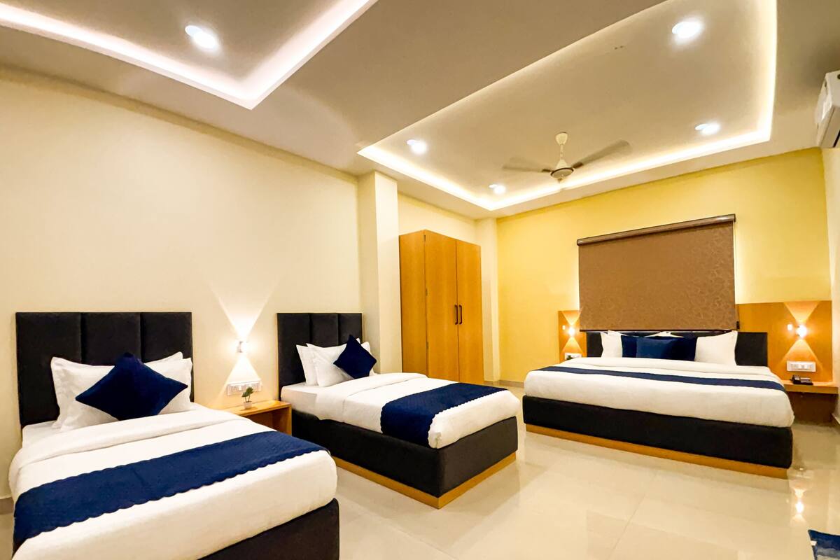 A hotel room with two beds, a wardrobe, a ceiling fan, and recessed lighting.