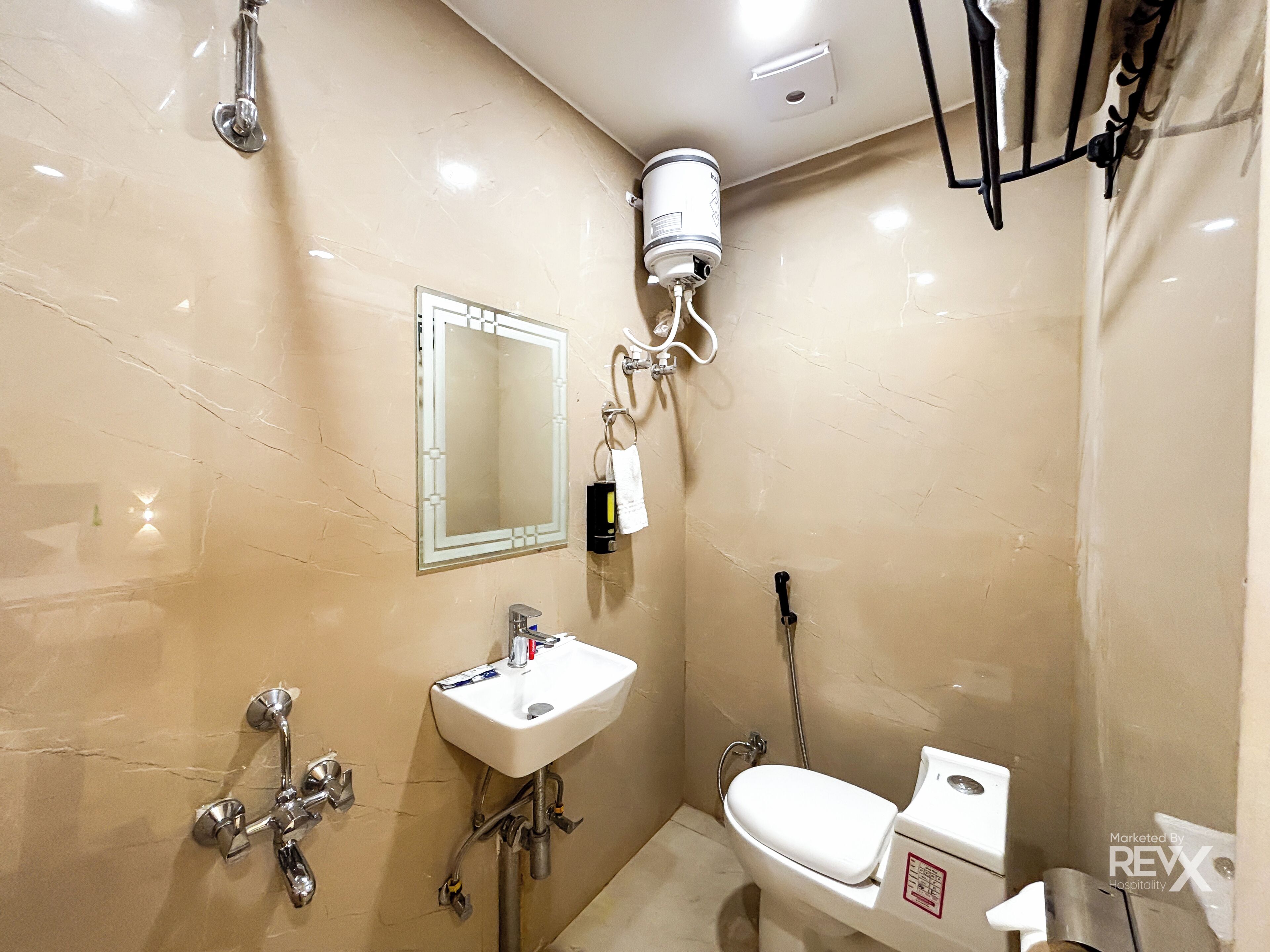 A bathroom with a sink, mirror, toilet, and shower.