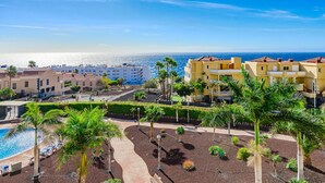 Un complexe hôtelier doté d’une piscine, de palmiers et offrant une vue sur l’océan.