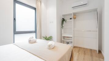 Een moderne hotelkamer met een groot bed, een kledingkast en een raam.