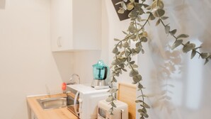 A kitchenette with a toaster, a blender, and a sink.
