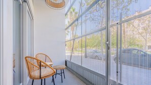 A balcony with two wicker chairs and a view of a parking lot through a metal fence. - Loft HomeValencia by Host Valencia (Valencia)