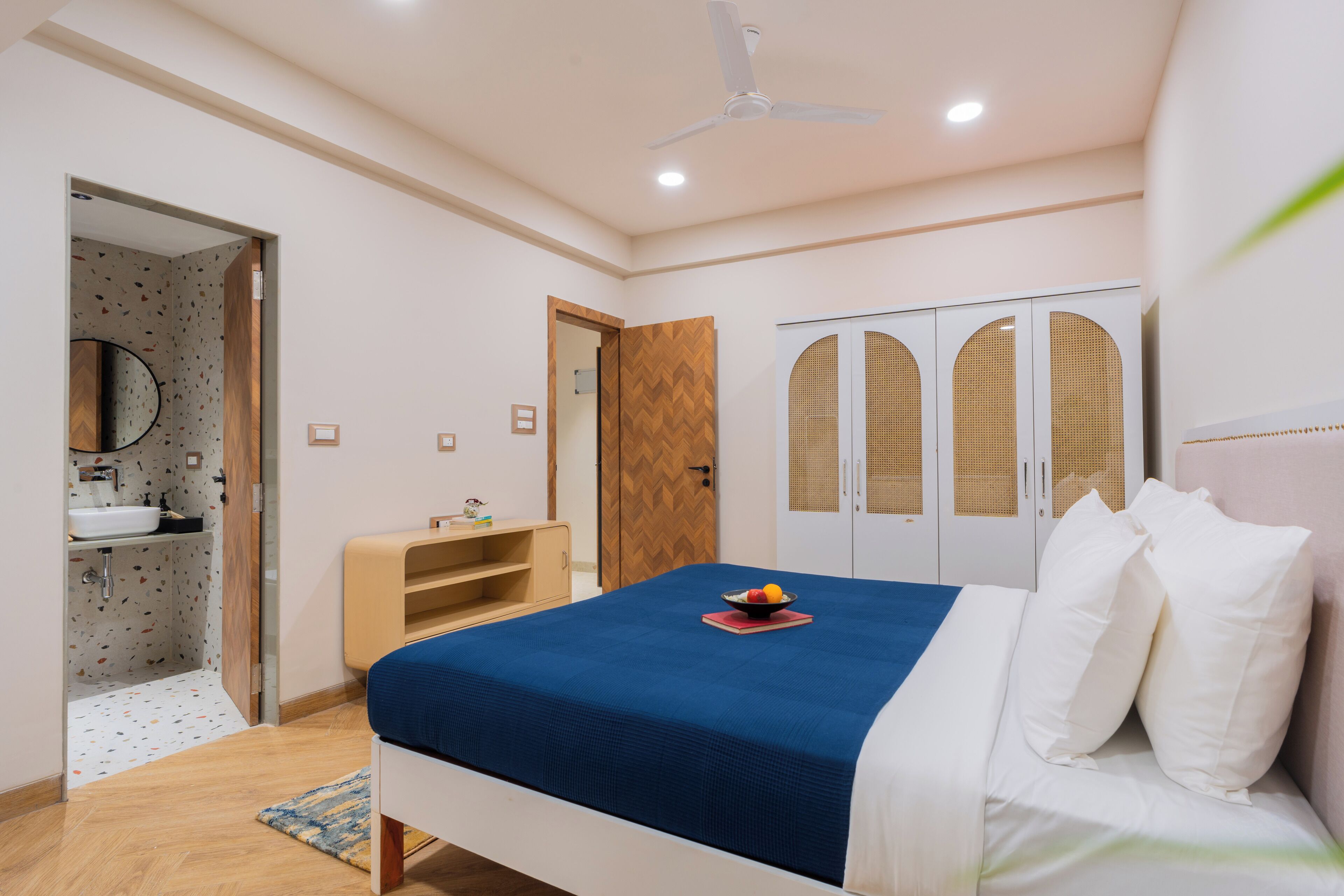 Una camera da letto con un letto, un armadio, uno specchio e un bagno.
