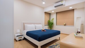 A modern hotel room with a bed, bedside table, nightstand, air conditioning unit, window, and a mirror. - ELIVAAS Kamerios Verano 1 BHK with Pool (Marra)
