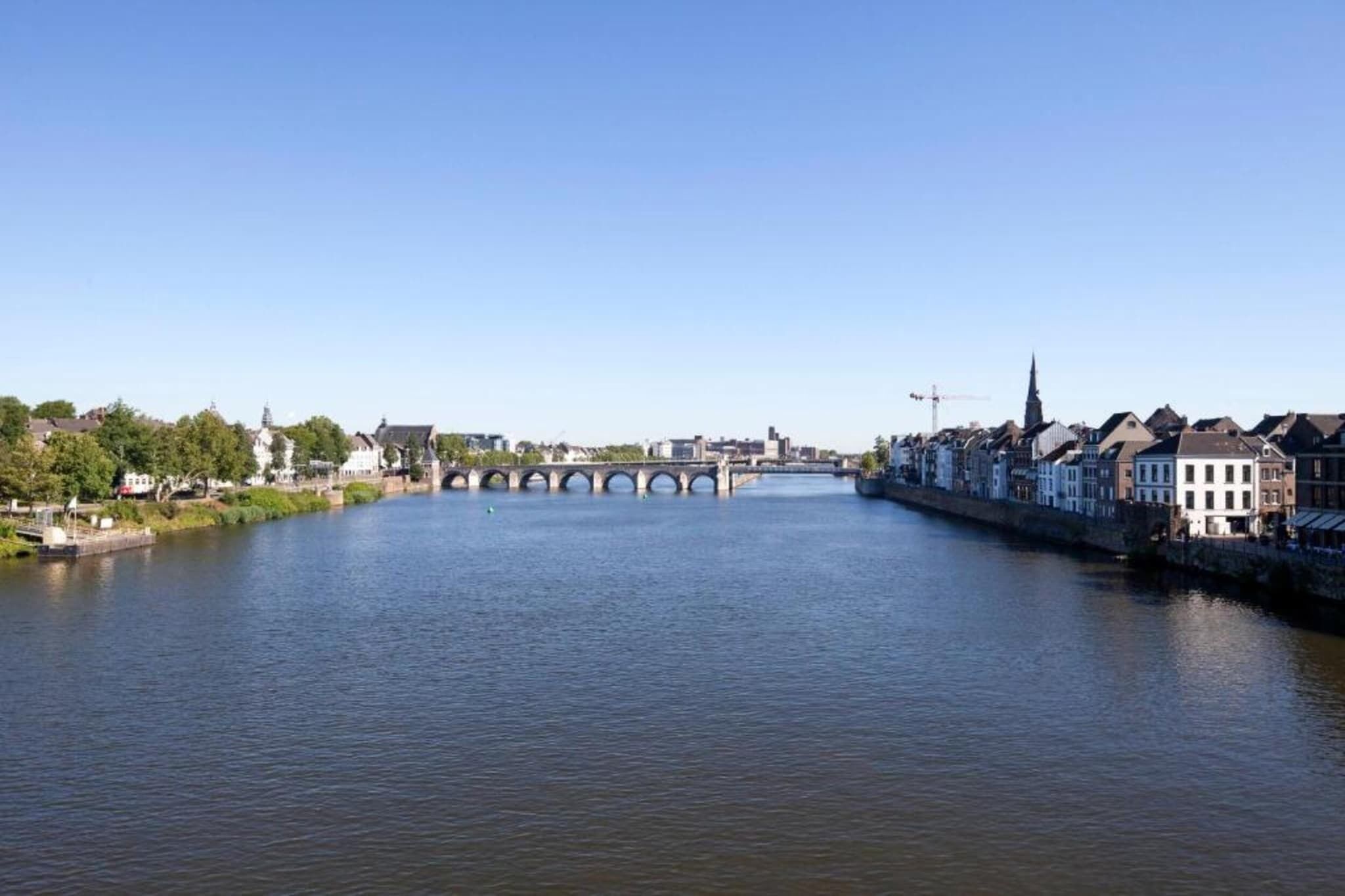 Ein Fluss mit einer Brücke und Gebäuden am Ufer.