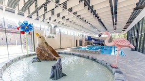 Ein Hallenbad mit einer Delfin-Skulptur, einer Flamingo-Skulptur und einer Vogel-Skulptur.