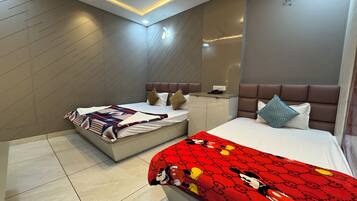 A modern hotel room with two beds, a ceiling fan, recessed lighting, and a minibar.