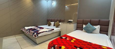 A modern hotel room with two beds, a ceiling fan, recessed lighting, and a minibar.