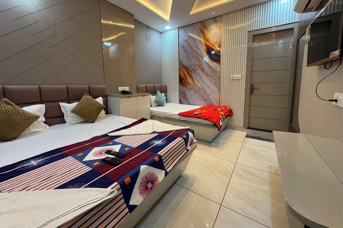 A modern hotel room with a large bed, a desk, and a vanity.