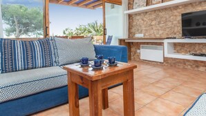 A living room with a sofa, a coffee table, and a TV. - Brat Salions by Interhome (Tossa de Mar)